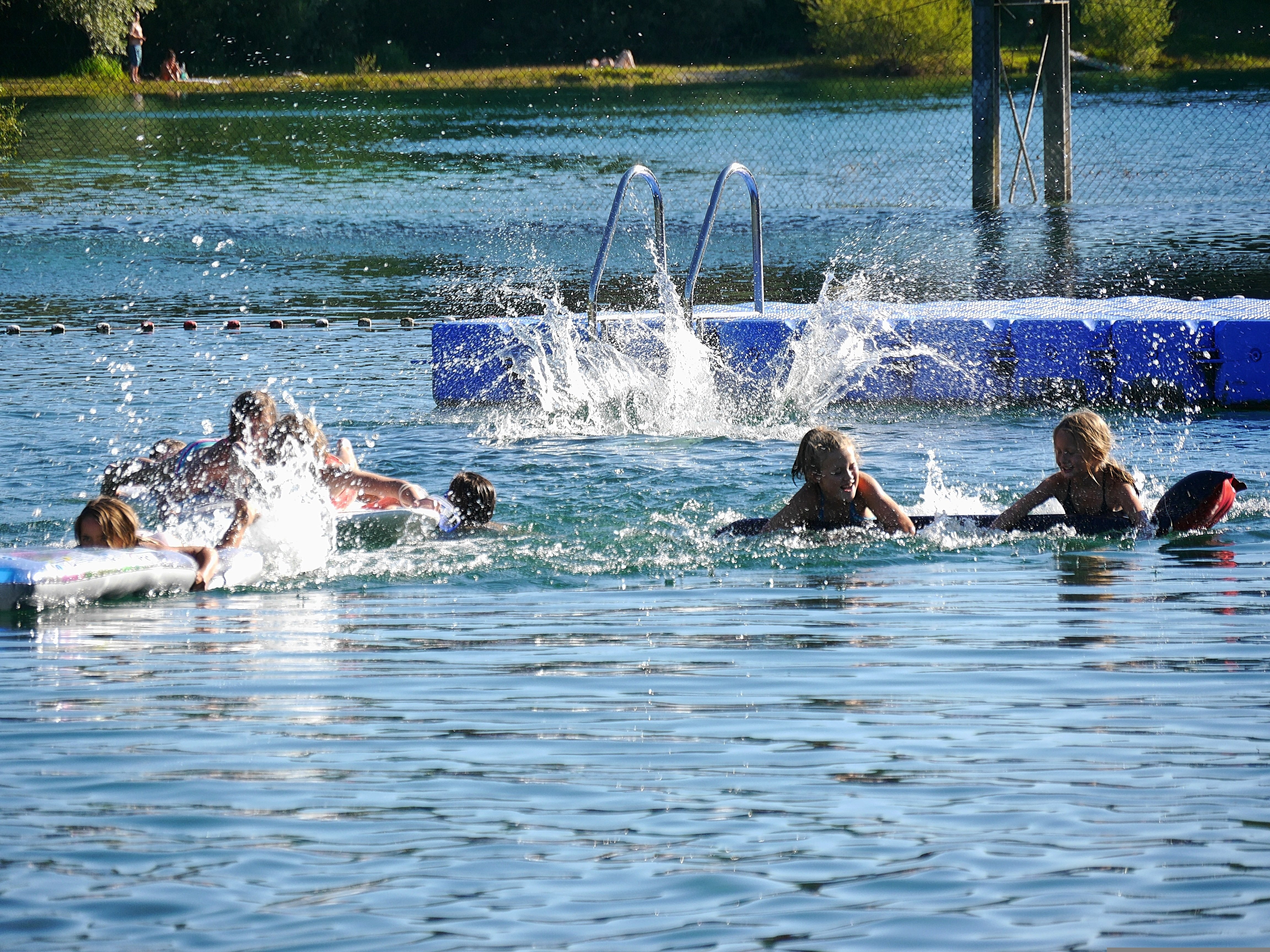 Menschen im Badesee spritzen sich an. 